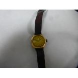 Vintage unmarked yellow metal wristwatch on fabric strap by Record