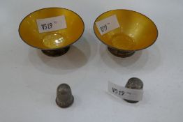 Two sterling silver thimbles of decorative design, and two sterling trinket dishes with yellow ename