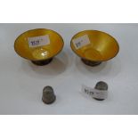 Two sterling silver thimbles of decorative design, and two sterling trinket dishes with yellow ename