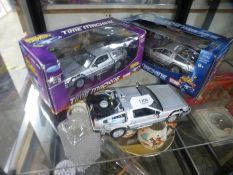 Two boxed die cast models of The Back to The Future Delorean and another by Welly unboxed
