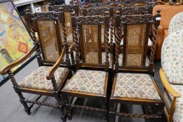 A set of 6 oak dining chairs having carved splats with cane backs, to include a pair of carver chair