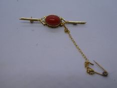 18ct yellow gold bar brooch with safety chain and oval cabochon orange hardstone, marked 750, 3.1g