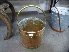 An old copper coal bucket having brass banding