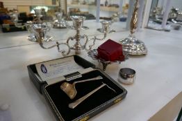 A mixed lot comprising one silver christening pusher, two sterling napkin rings. A white metal sh