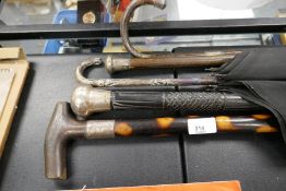 Four silver mounted walking sticks and a silver handled umbrella