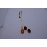 9ct yellow gold pendant set with amber stone marked 375 and a matching pair of earrings, also marked