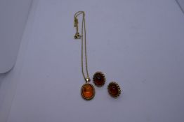 9ct yellow gold pendant set with amber stone marked 375 and a matching pair of earrings, also marked