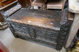 An antique carved oak window seat having rising lid, 102cm