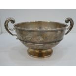 A silver two handled bowl on a pedestal foot and decorative handles, hallmarked London 1911, Robert