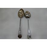 A pair of silver gilt tablespoons, heavily decorated with engraved and embossed design of fruit and