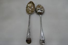 A pair of silver gilt tablespoons, heavily decorated with engraved and embossed design of fruit and