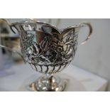 Silver ornate trinket box on four dainty feet, marks worn with a decorative trophy cup of foliate de