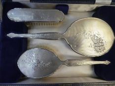 A very high quality cased, silver backed dressing table set consisting of two brushes and a hand mir