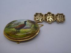 Yellow metal Chinese design brooch together with oval porcelain panel depicting pheasant grazing wit