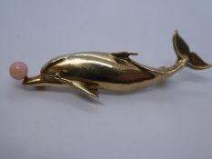 9ct gold brooch in the for of a Dolphin with a coral ball resting on its snout approx 6cm, maker KC,