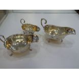 Three silver sauceboats of various sizes on three feet, decorative designs and different hallmarks,