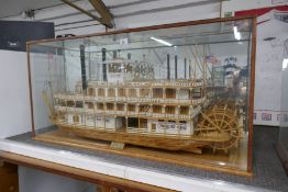A wooden model of 19th century New Orleans Paddle Steamer in glazed case, with associated wrought ir