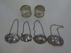 Four silver decanter labels of ornate decoration and various hallmarks and a pair of thick, silver n