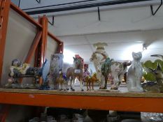 A selection of china ornaments to include horses, cat, deer, man laying on a bench, glass fish, etc