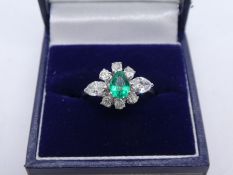 Pretty 1940s Platinum dress ring with central pear shaped natural Emerald surrounded by 6 round cut