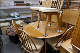 An Ercol style 2 flap kitchen table on splay legs and a set of 6 stick back dining chairs