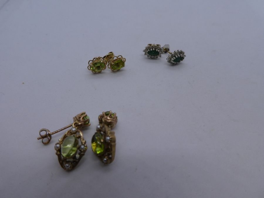 Three pairs of 9ct yellow gold earrings, one a pair cabochon peridot drop example, another a pair o