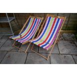 A pair of stripe wooden deck chairs