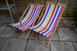 A pair of stripe wooden deck chairs