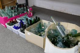 A large quantity of coloured and clear glass bottles, some 19th century