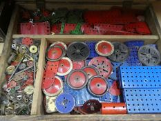 A wooden box containing  various vintage pieces of Meccano