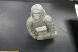 An Inuit carving of kneeling man, holding a seal