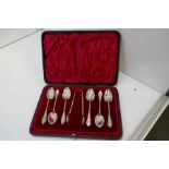 A cased set of six decorative Victorian silver spoons and a pair of silver tongs. With a twisted han