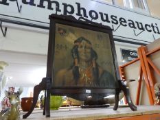 A wooden free standing fire screen with a painted front of a Native American