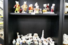 A quantity of Beswick Rupert Bear figures and similar, some limited edition, and a shelf of armorial