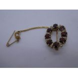 9ct yellow oval brooch with safety chain inset with garnet and diamond chips, marked 375, 2.5cm appr