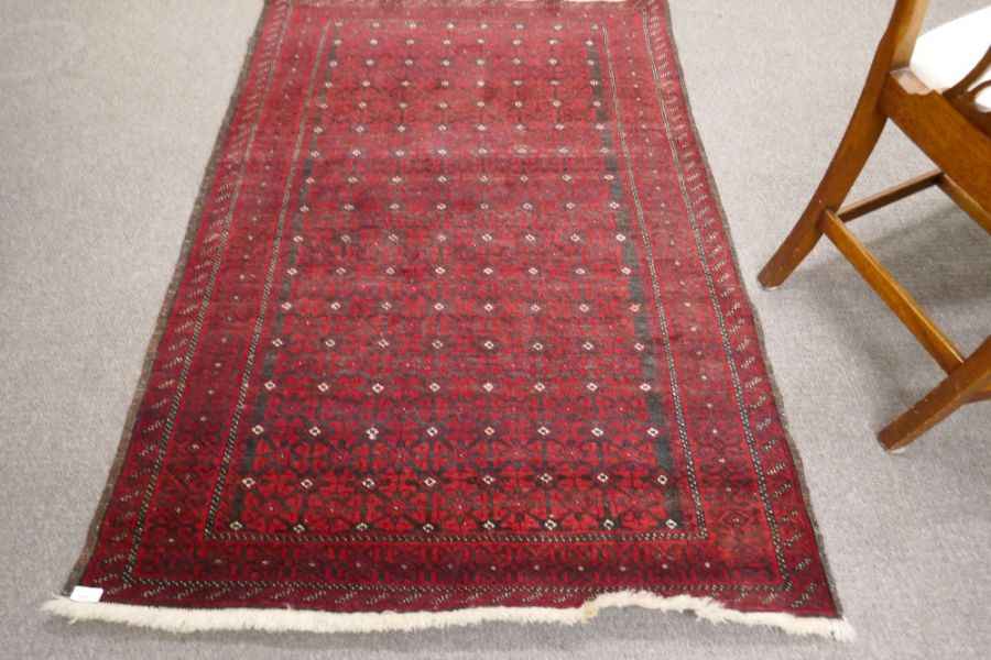 An Afghan red rug having repeated design, 172cm