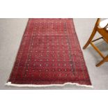 An Afghan red rug having repeated design, 172cm