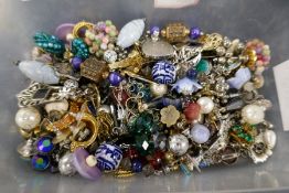 A large quantity of earrings, a silver charm bracelet, silver rings and a hardstone brooch