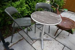 A metal Bistro table and two metal folding chairs