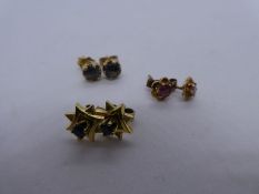 Three pairs of 9ct yellow gold studs, all marked 375, one pair set rubies, one pale blue sapphire an