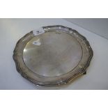 A heavy silver tray on three feet with a circular form, hallmarked Atkin Brothers 1913 Sheffield, we