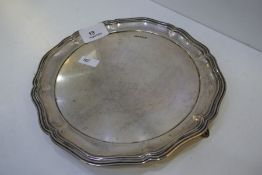 A heavy silver tray on three feet with a circular form, hallmarked Atkin Brothers 1913 Sheffield, we