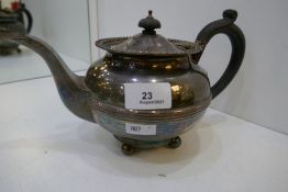 A heavy silver teapot with gadrooned rim on four ball feet, hallmarked London 1938 F T Ray and Co, t