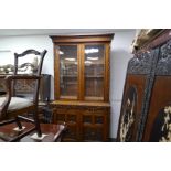 An early 20th century carved oak bookcase, having two drawers on plinth base, height 227cms