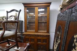 An early 20th century carved oak bookcase, having two drawers on plinth base, height 227cms