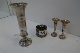 A silver hand hammered design flute vase 15cm approx. Along with two silver miniature candlesticks,