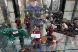 A small shelf of resin oriental figures and dragon and a green stone lion, etc