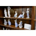 Two shelves of Lladro and Nao figures, and a Collector's Society plaque