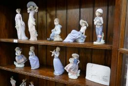 Two shelves of Lladro and Nao figures, and a Collector's Society plaque