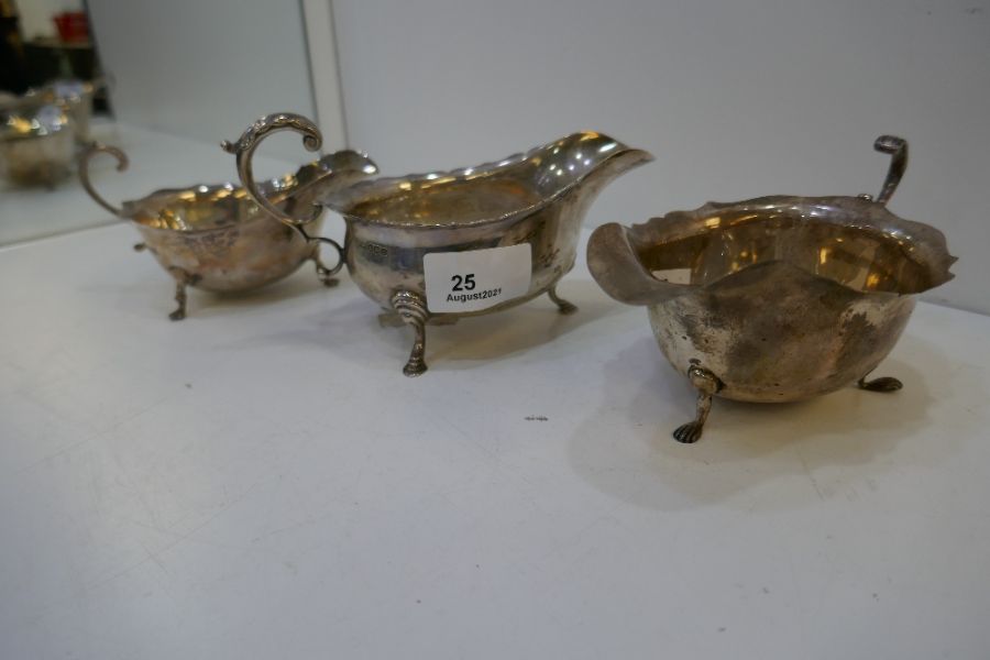 Three silver sauceboats with scalloped edge design, one being Mappin and Webb, Sheffield 1930, one B